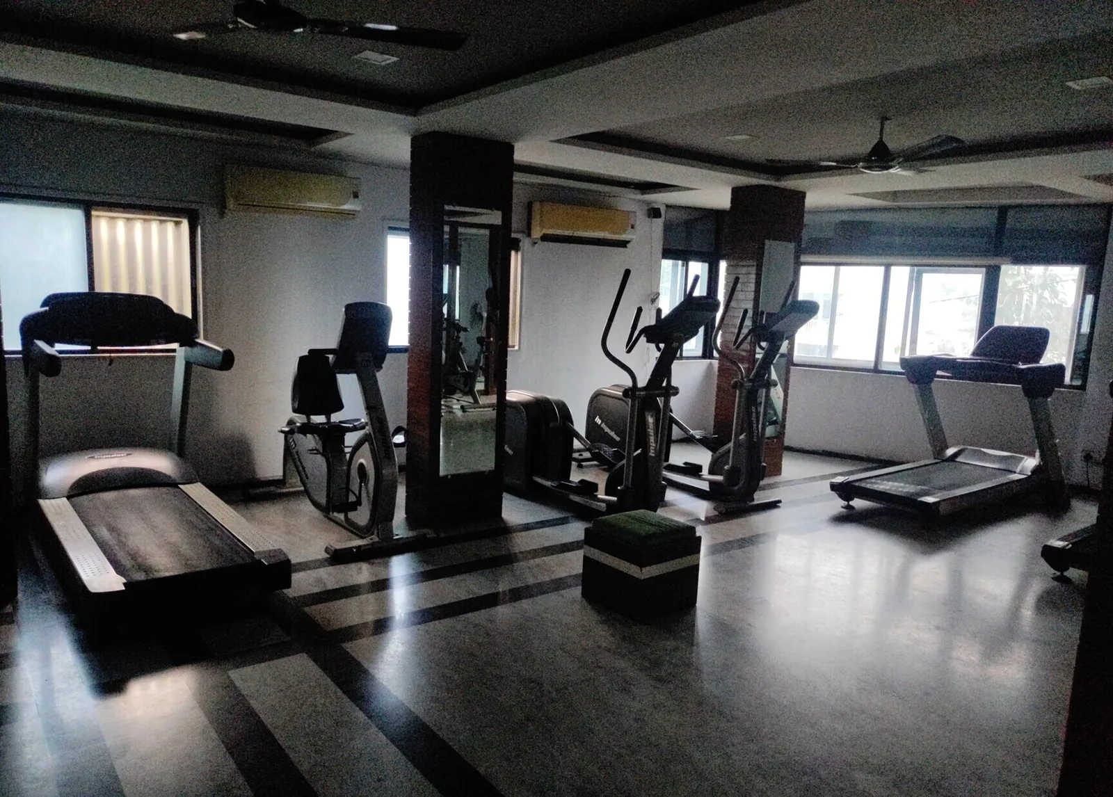 The cardio area at S R Gym Katargam, Surat, with treadmills, cross trainers and a recumbent bike