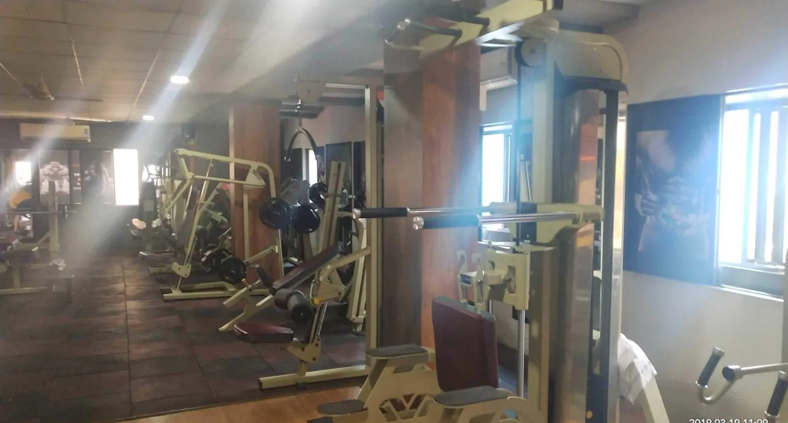 Plate-loaded machines and a cable crossover along the length of the floor at S R Gym Katargam, Surat