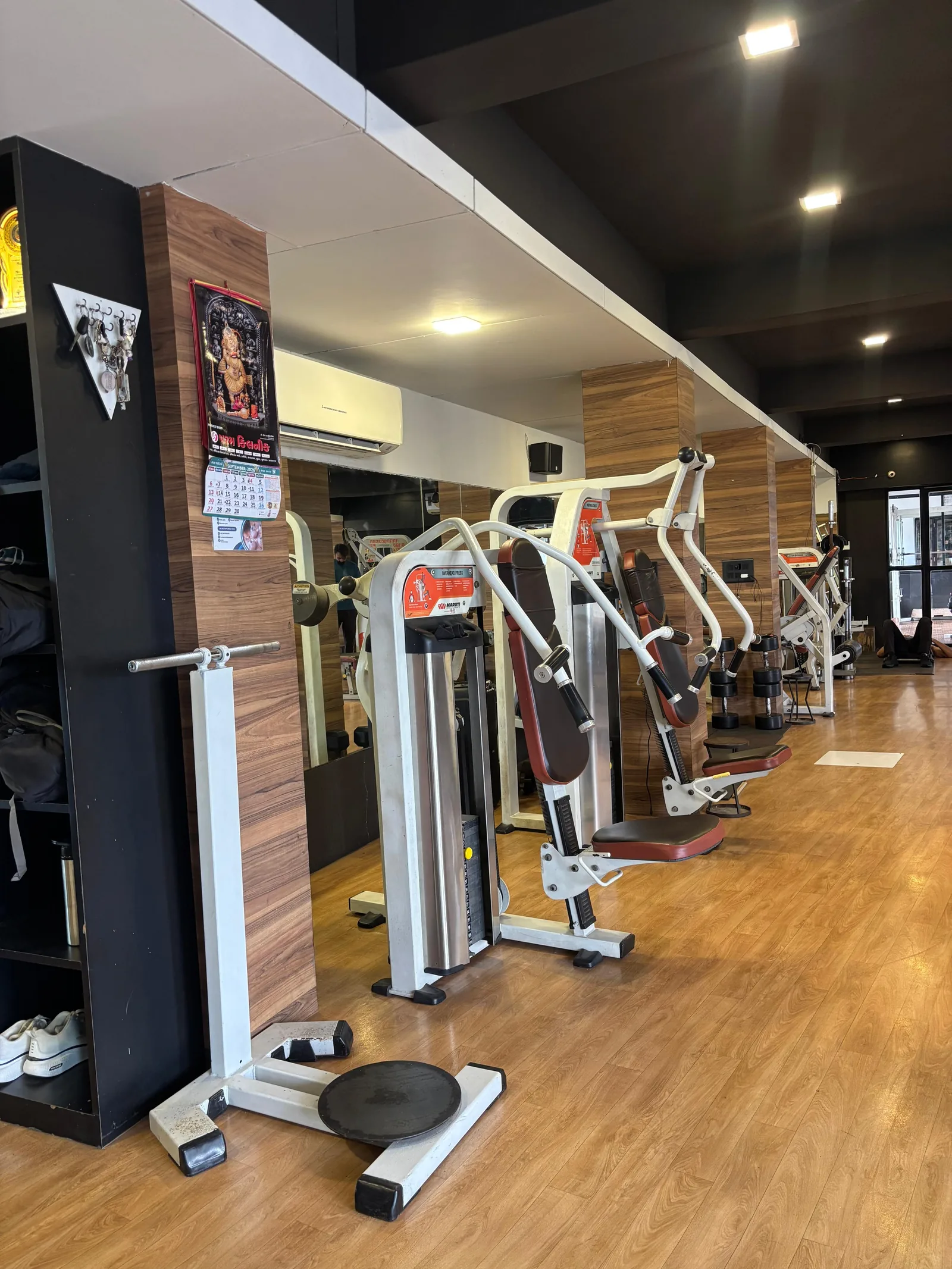The main training floor at S R Gym Adajan, Surat, with pin-loaded machines along a mirrored wall