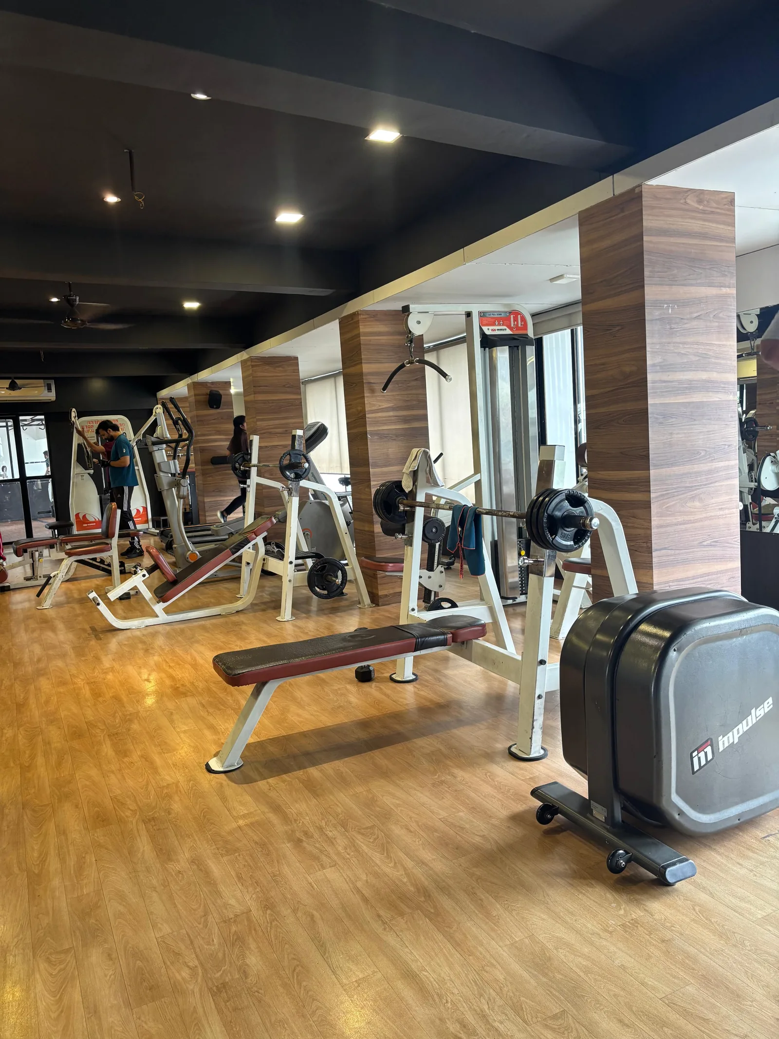 Free weights area with benches and barbells at S R Gym Adajan, Surat